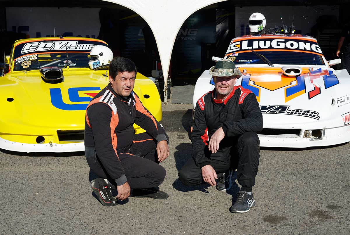 Hermanos Goya posando junto a los autos enfrente del box.