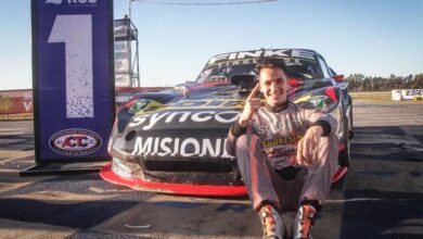 Bundziak apoyado en el auto haciendo el uno.