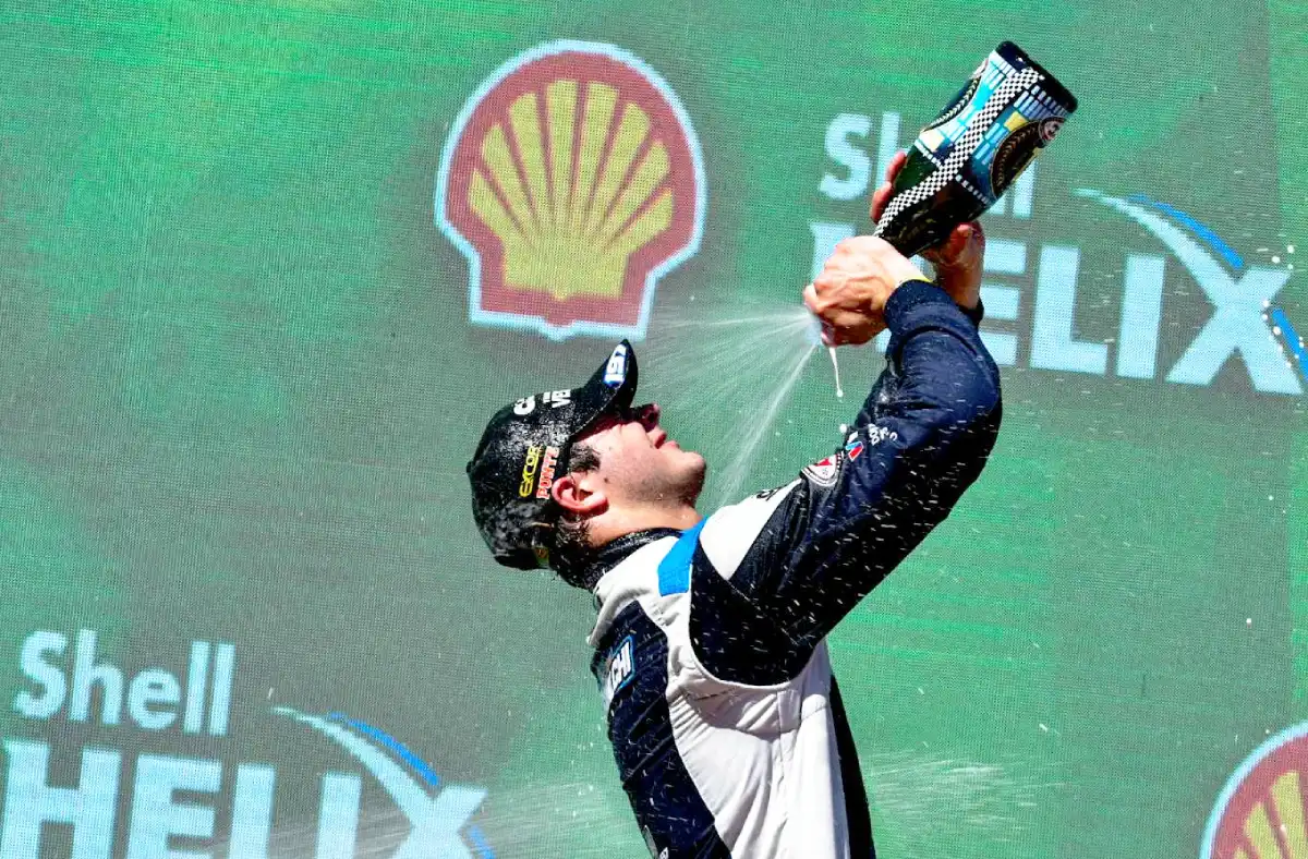 Scialchi celebrando en el podio de El Calafate con champagne.