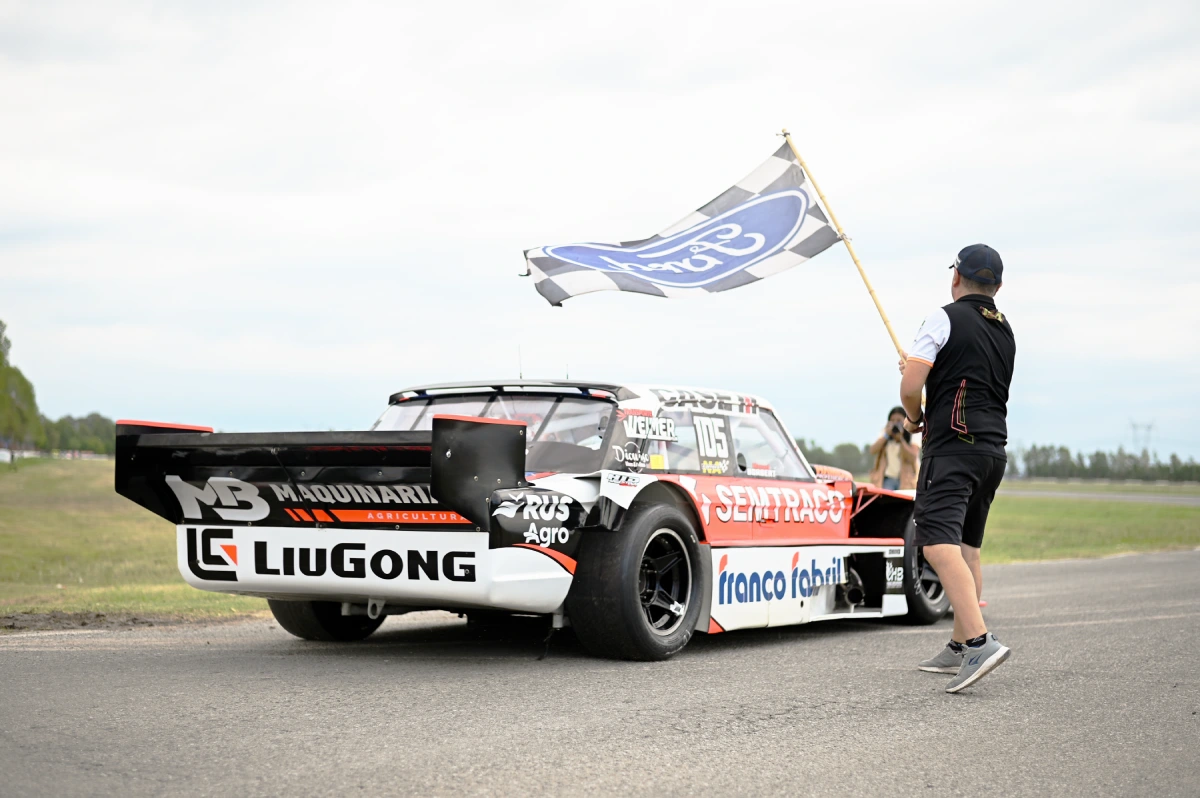 Ford de Borgert en la grilla de La Plata junto a un hincha con la bandera de Ford.