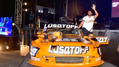 Lambiris saludando desde la puerta de su Ford.