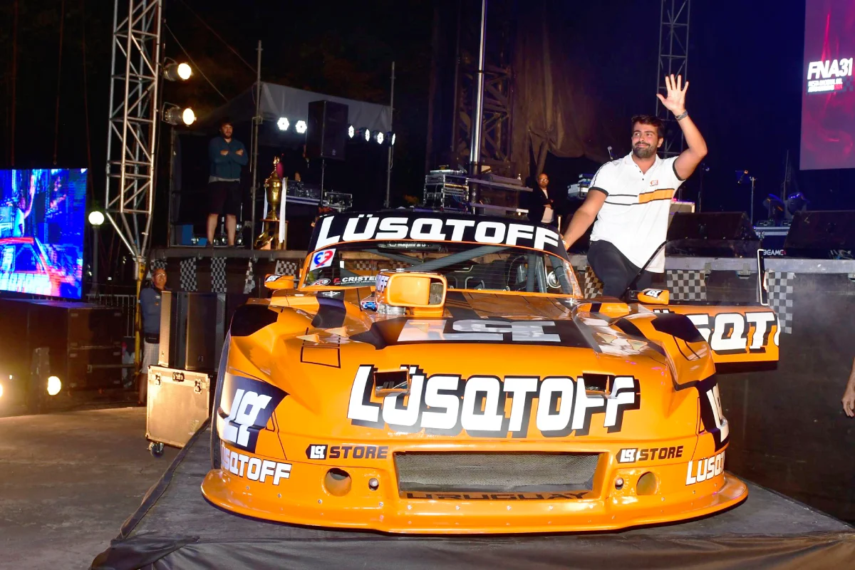 Lambiris saludando desde la puerta de su Ford.